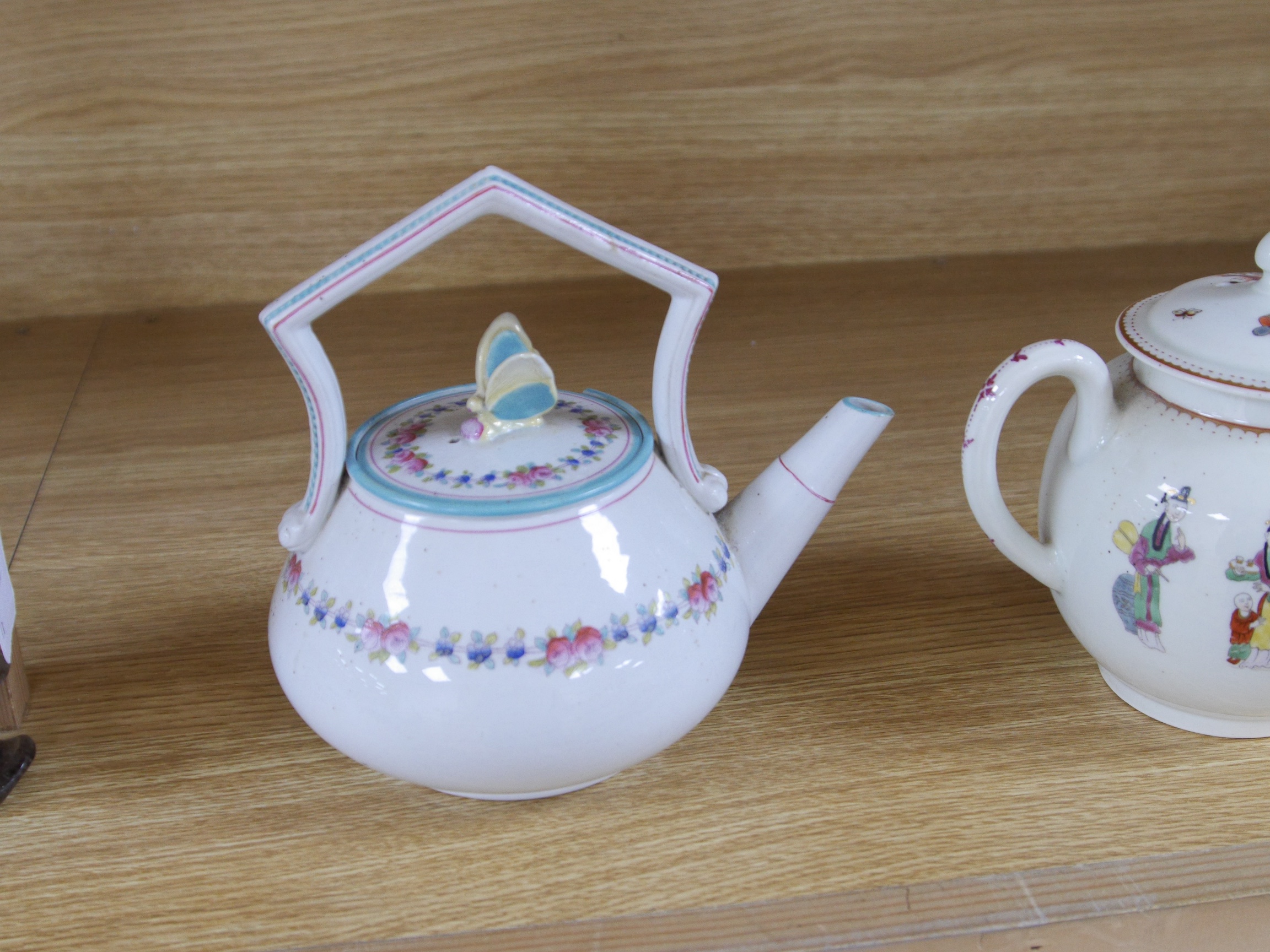 A Worcester chinoiserie teapot, c.1770 and a Victorian teapot with decorative butterfly cover, chinoiserie teapot 16cm high. Condition - damage to rim of Victorian teapot.